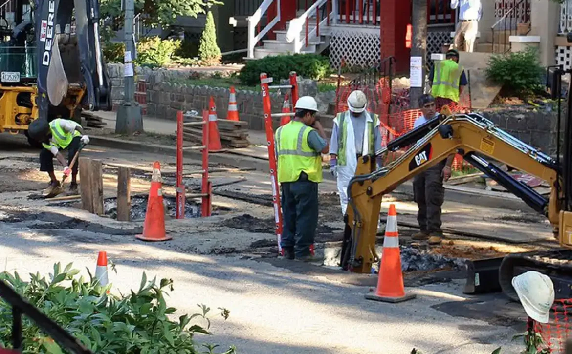 Workers replacing lead pipes in a community