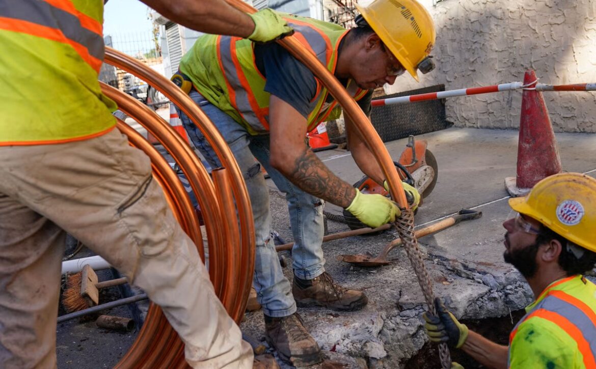 Workers replacing lead pipes in a trench
