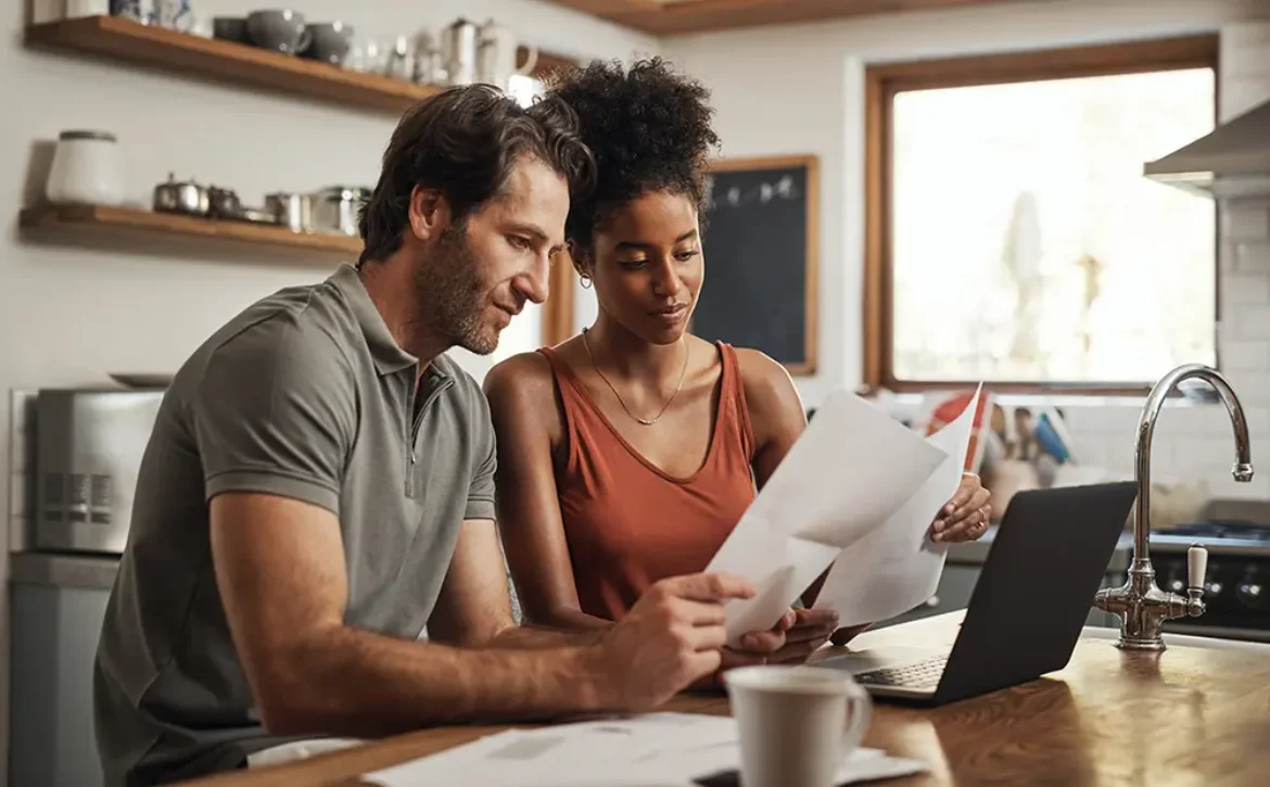 Couple using laptop in the kitchen