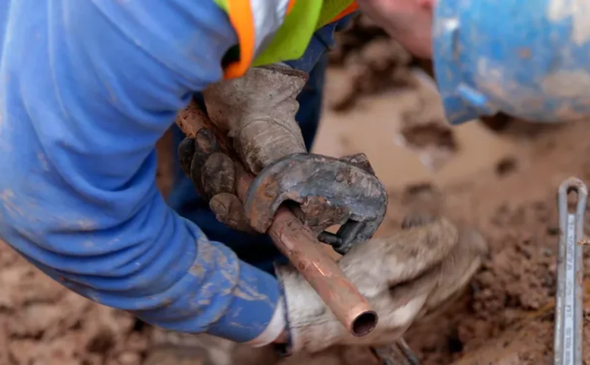 Construction worker installing a copper water pipe