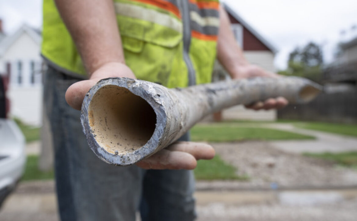 Construction workers holding a lead pipe