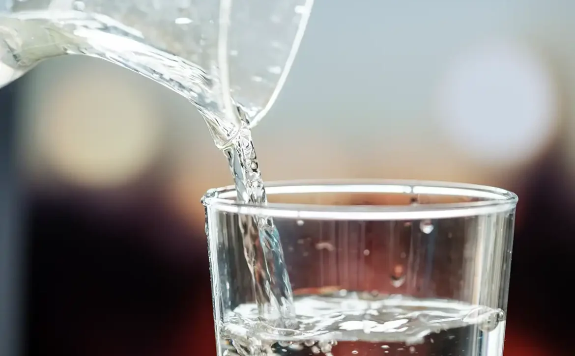 Macro shot pouring water into glass